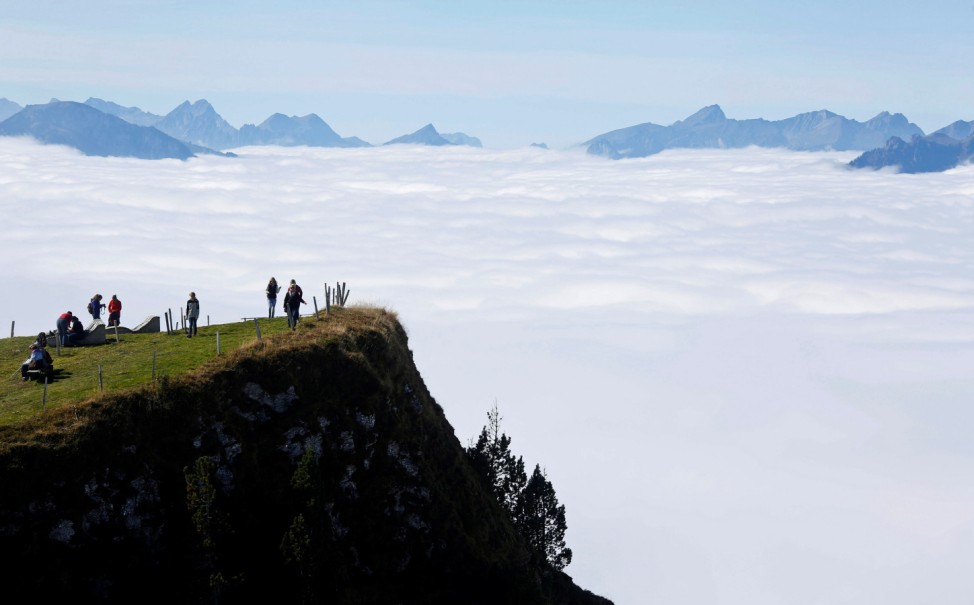 Tourists walk in the sun on the Niederhorn mountain near Interlaken