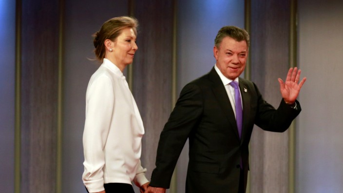 Colombia's President Juan Manuel Santos and his wife arrive ahead of a news conference at Narino Palace in Bogota