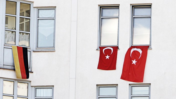 A German national flag is set up next to Turkish national flags at apartment building in Berlin