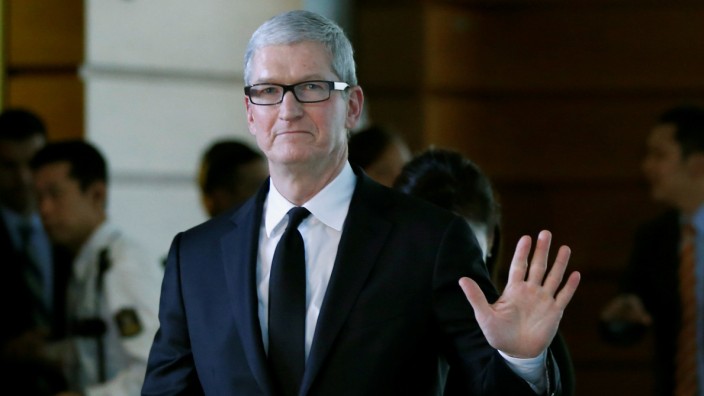 Apple Inc CEO Tim Cook waves after meeting with Japan's PM Abe at Abe's official residence in Tokyo