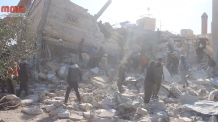 Still image taken from video shows people gathering near a destroyed building said to be a Medecins Sans Frontieres (MSF) supported hospital in Marat al Numan, Idlib, Syria