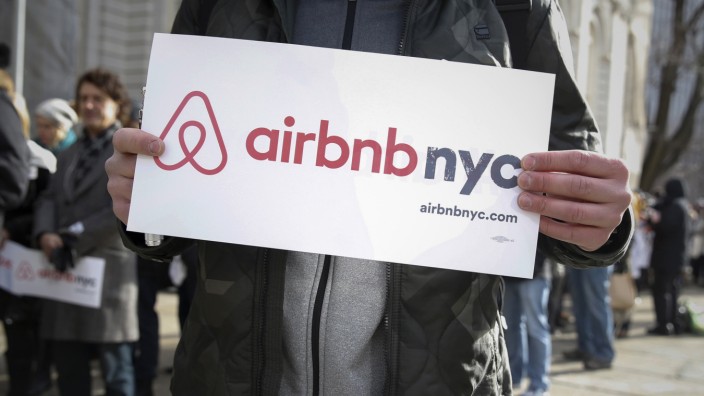 Supporters of Airbnb stand during a rally before a hearing at City Hall in New York