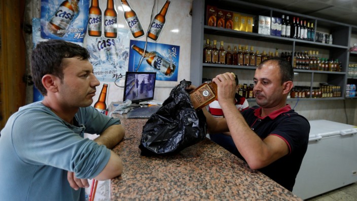 An Iraqi man buys alcohol from a wine shop in Baghdad, Iraq