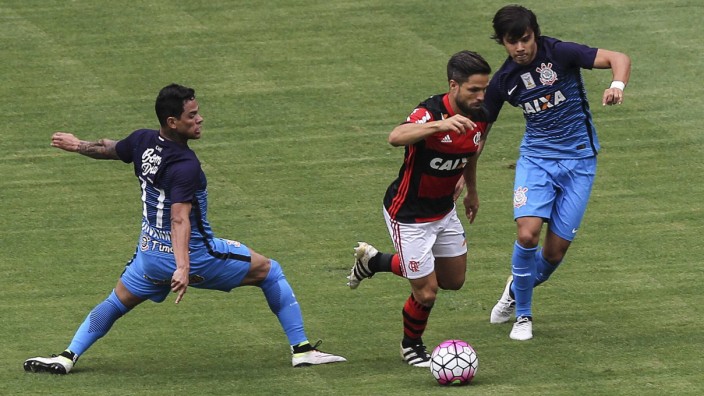 Flamengo s Diego c in action against Giovanni Augusto L and Romero R of Corinthians during th; Flamengo diego