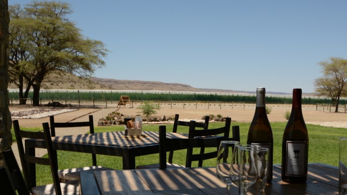 Namibia: Auf der Veranda überblicken Gäste der Farm bei einem Glas Shiraz Weinstöcke und Steinwüste.