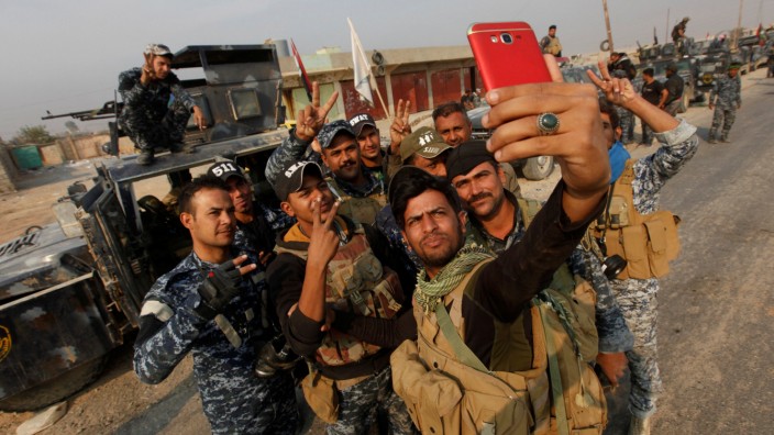Federal police forces members take a selfie in Qayyara, south of Mosul