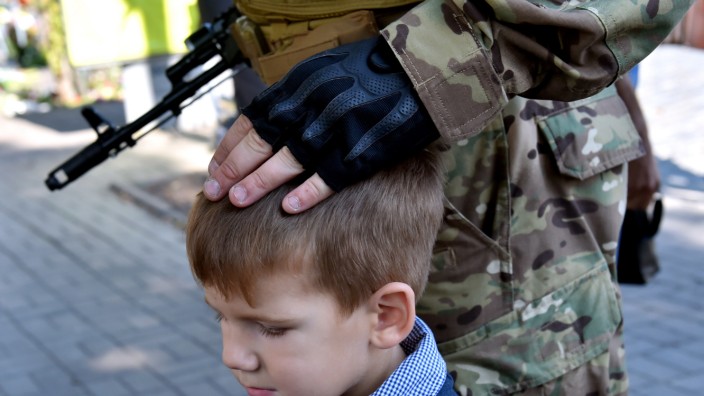 Ukraine: Ein Soldat eines ukrainischen Freiwilligenbataillons tätschelt einen kleinen Jungen bei einer Vereidigung in Kiew.