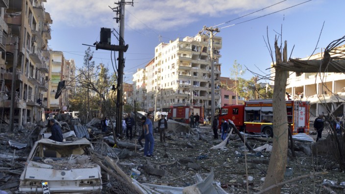 Diyarbakir: Menschen blicken auf den Schaden, den ein Bombenattentäter in der türkischen Stadt Diyarbakir angerichtet hat. Bei der Tat kamen neun Menschen ums Leben, darunter der Attentäter selbst.