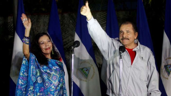 Daniel Ortega shows his ink stained thumb to the media beside his wife Rosario Murillo after they casting their vote at a polling station during Nicaragua's presidential election in Managua