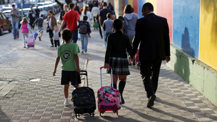 School children walk with their parents to school in Tomares