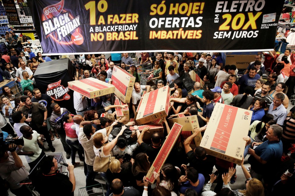 Shoppers reach out for television sets as they compete to purchase retail items on Black Friday at a store in Sao Paulo
