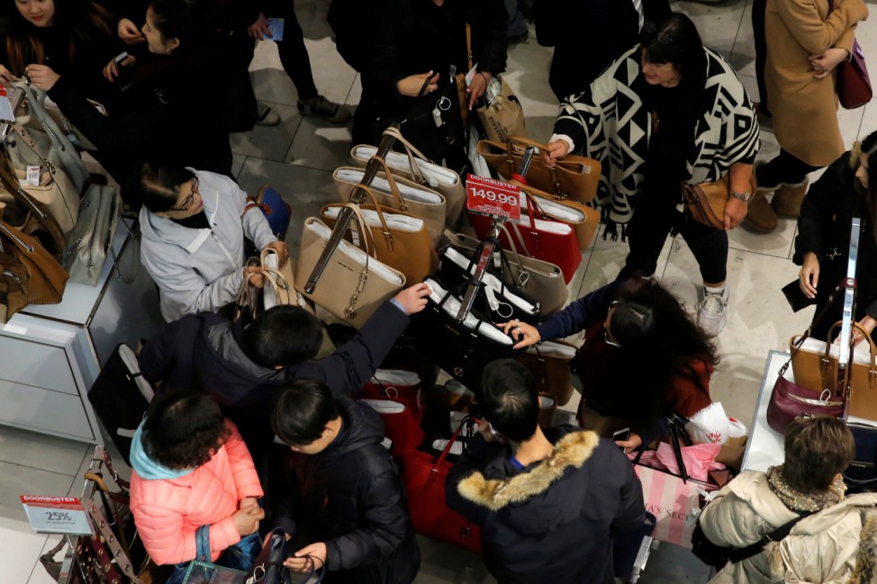 People look at a rack of handbags during early Black Friday sales at Macy's Herald Square in Manhattan, New York, U.S.