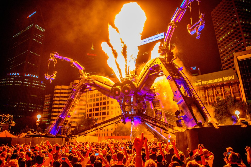 Spectators watch Aboriginal dancers and acrobats perform with a 50-tonne Arcadia spider, constructed from used repurposed military hardware, during a laser and pyrotechnics show in Perth