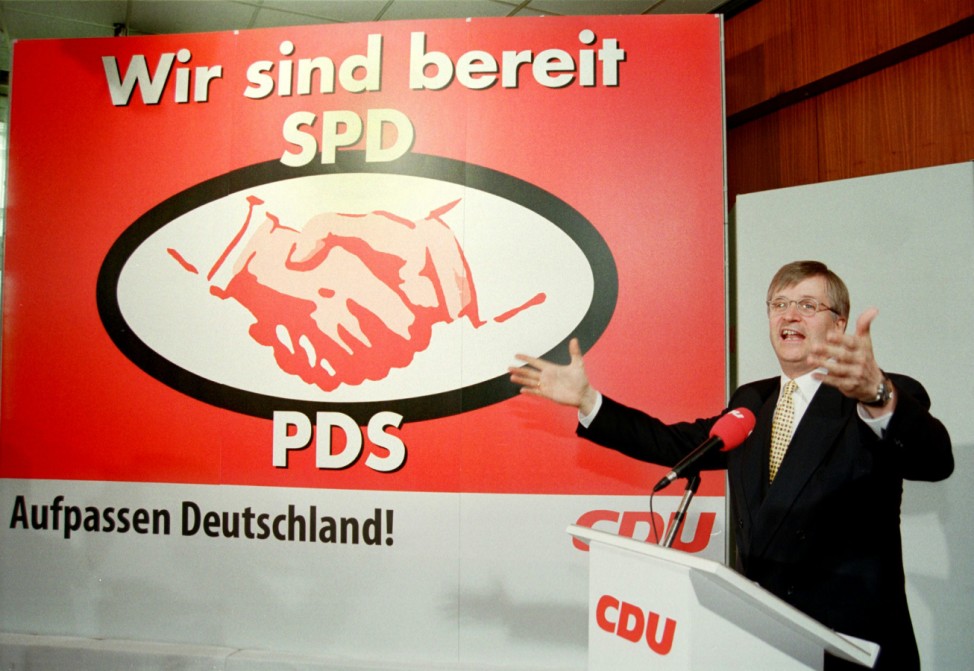 CHRISTIAN DEMOCRATIC PARTY MANAGER HINTZE SHOWS CAMPAIGN POSTER IN BONN
