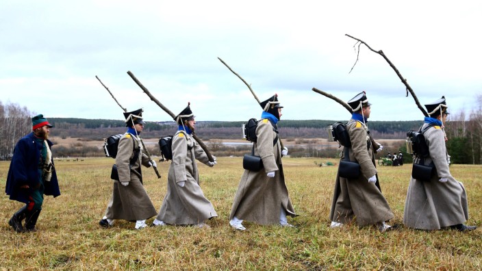 People dressed in the historic uniforms of the Imperial Russian army take part in a re-enactment of the 1812 Battle of Berezina, to mark the 204th anniversary of the battle, near the village of Bryli