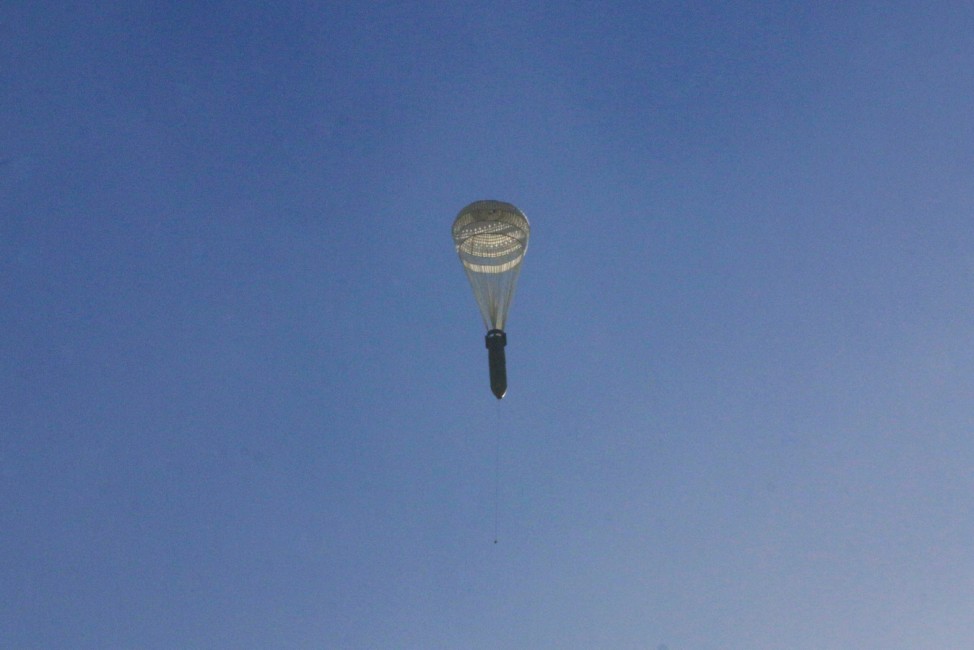 A missile hangs on a parachute while falling over the rebel-held besieged al-Qaterji neighbourhood of Aleppo
