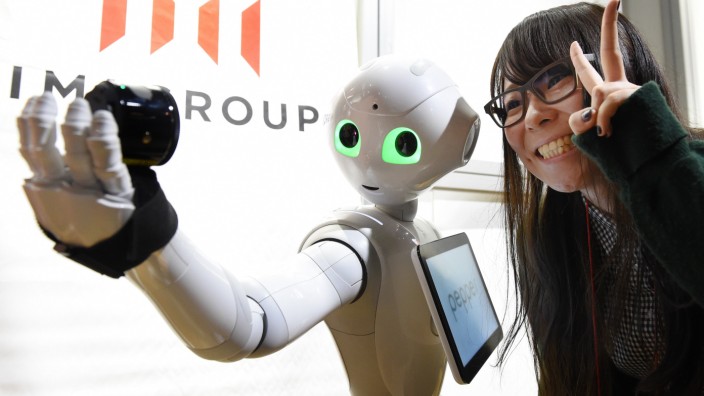 Digitalisierung: Eine Frau posiert mit einem Roboter für ein "Selfie".