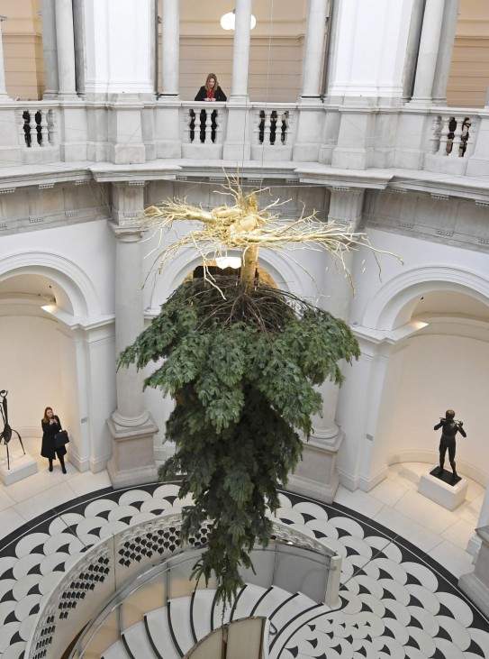 Employees and visitors view a Christmas tree, by Iranian born artist Shirazeh Houshiary as part of the Festive Commission at the entrance to the Tate Britain gallery in London Britain