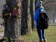 A woman looks at flowers and messages attached on a tree near the site where a 19-year-old female student was found dead in Freiburg