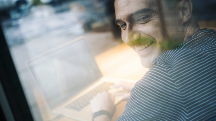 Smiling man using laptop model released Symbolfoto PUBLICATIONxINxGERxSUIxAUTxHUNxONLY GIOF01595