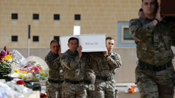 Armed Forces of Malta soldiers carry coffins with the bodies of migrants to an inter-faith burial service at Mater Dei Hospital in Tal-Qroqq