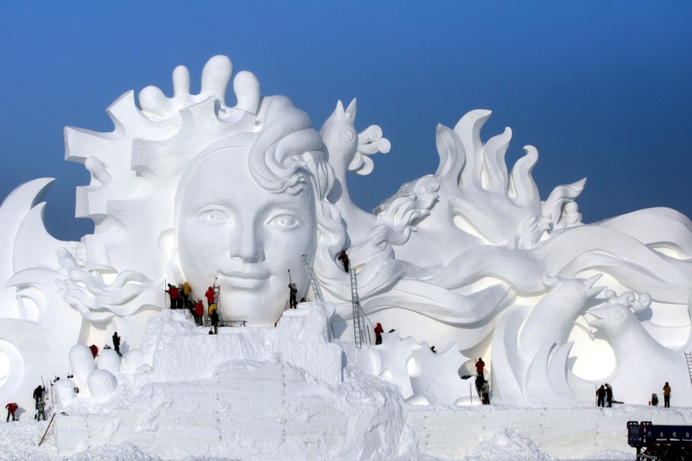 Artists work on snow sculptures at an exhibition in Harbin