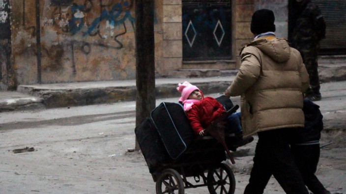Krieg in Syrien: Ein Mann in Aleppo versucht, seine Kinder in Sicherheit zu bringen.