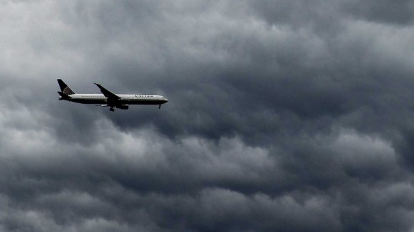 A plane flies under rain clouds near Haarlem