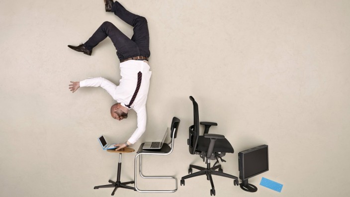 Businessman doing handstand while working on laptop model released Symbolfoto PUBLICATIONxINxGERxSUI