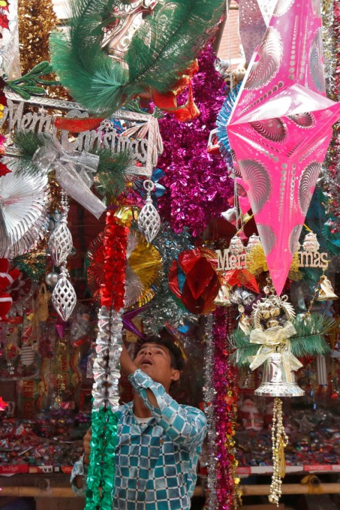 A vendor hangs decorative items for sale at his roadside stall ahead of Christmas in Kolkata