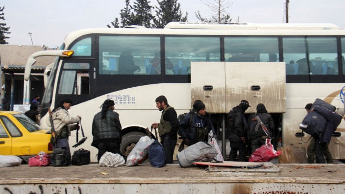 Krieg in Syrien: Syrische Rebellen steigen in Khan al-Assal aus dem Bus, der sie aus Aleppo weggebracht hat.