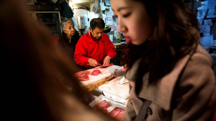 Japan: Ein Mann schneidet für Kunden Fisch am Tsukiji-Fischmarkt in Tokio.