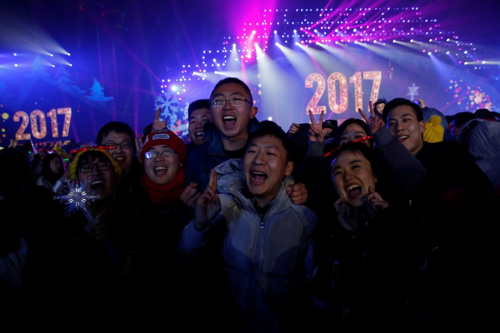 People pose for pictures as they attend a New Year's Eve countdown event in Beijing, China