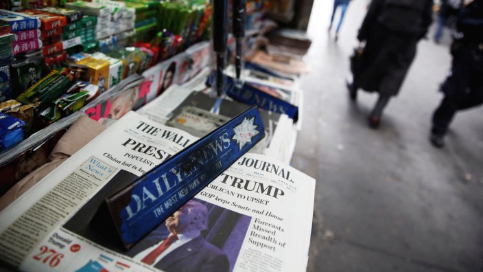 The cover of the Wall Street Journal newspaper is seen with other papers at a news stand in New York