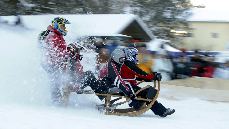Competitors ride wooden sledge during Bavarian horn sledge race in Garmisch-Partenkirchen