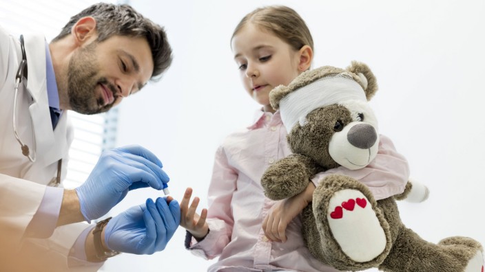 Doctor treating girl holding teddy model released Symbolfoto property released PUBLICATIONxINxGERxSU