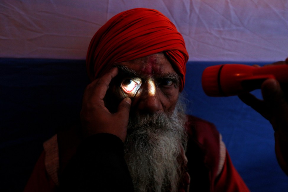 A Sadhu or a Hindu holy man undergoes an eye examination at a free eye-care camp organised by social workers at a makeshift shelter, before heading for an annual trip to Sagar Island for the one-day festival of 'Makar Sankranti', in Kolkata