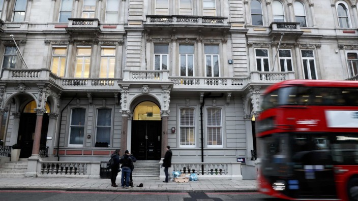 People stand outside the building housing the offices of Orbis Buiness Intelligence (C) where former British intelligence officer Christopher Steele works, in central London