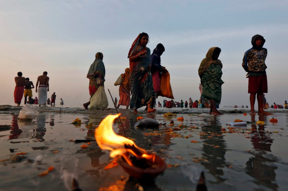 Hindu pilgrims walk after taking a dip at the confluence of the river Ganges and the Bay of Bengal a day after 'Makar Sankranti' festival at Sagar Island