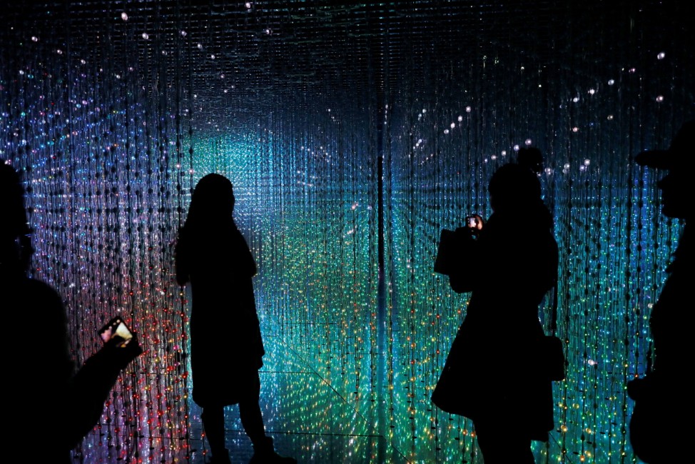 Visitors look at a digital installation which is a part of 'Dance! Art Exhibition, Learn & Play!' by Japanese group teamLab in Taipei