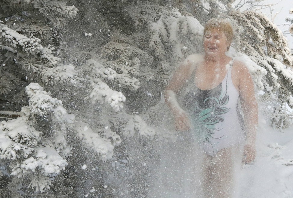 A member of the Cryophile amateur winter swimming club sprinkles herself with snow during a training session in Krasnoyarsk