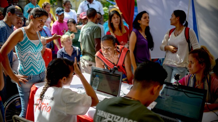 Südamerika: Schlange stehen für die "Karte des Vaterlands": Venezolaner stehen in Caracas an, um eine Bezugskarte für Lebensmittel zu bekommen.