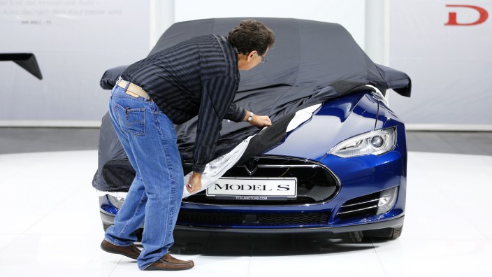 File photo of an employee covering a Tesla Model S car during the media day at the Frankfurt Motor Show in Frankfurt