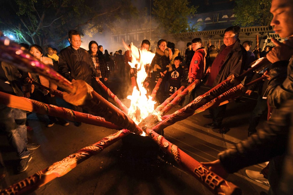 People burn incense as they celebrate the Lunar New Year of Rooster at a buddhist temple in Nanning