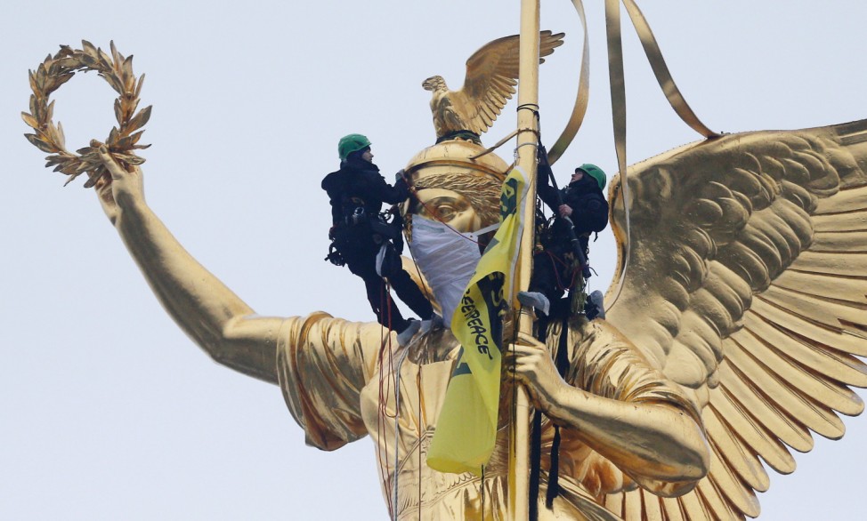 Greenpeace activists climb the Golden Victoria monument on top of the Victory Column and install a banner 'Breathless through the city' to protest against air pollution in Berlin