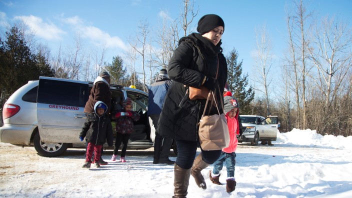 A family that claimed to be from Sudan leaves a taxi to walk across the U.S.-Canada border into Hemmingford, Canada, from Champlain in New York, U.S.