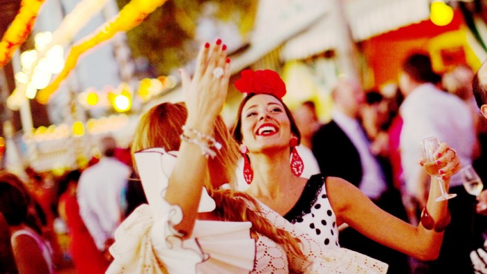 Women wearing Sevillana dresses dance during the traditional Feria de Abril (April fair) in the Andalusian capital of Seville