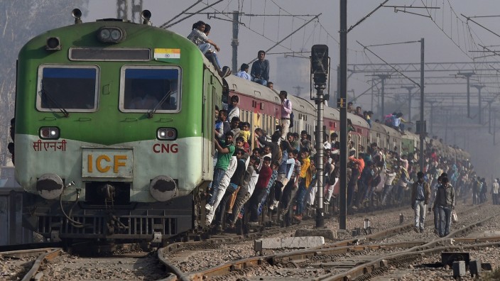 Freihandelsabkommen mit der EU: Bahnfahren auf indisch: Hunderte Passagiere klammern sich an den Waggons der überfüllten Züge fest. Die Regierung will die Eisenbahn nun modernisieren.