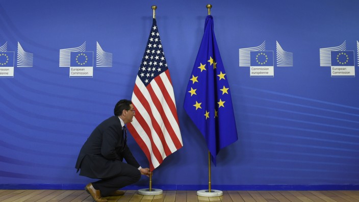 Handel mit den USA: Ein Mitarbeiter richtet die Flaggen der USA und der Europäischen Union.