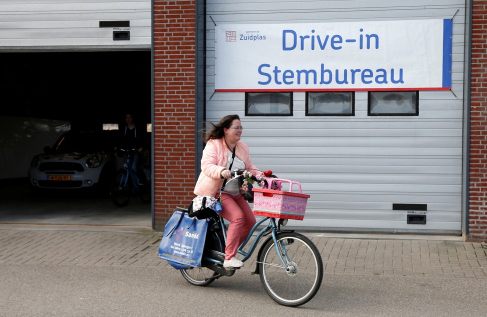 A cyclist leaves a drive-in polling station after voting in the Dutch general election in Zuidplas